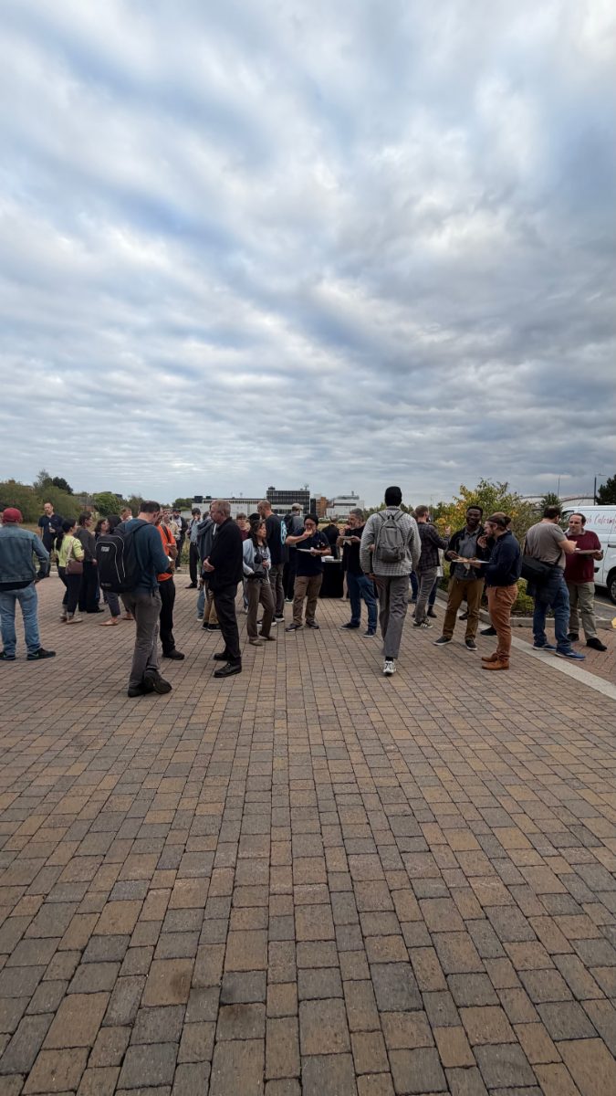 Attendees networking outside at DevTechTalks at Tripadvisor’s Oxford office, with groups chatting over food and drinks.